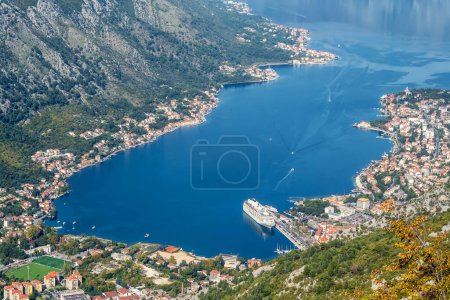 Foto de A panoramic aerial view of the Bay of Kotor, Monternegro with picturesque coastline, red roofs of houses and marina with boats and a large cruise ship. - Imagen libre de derechos