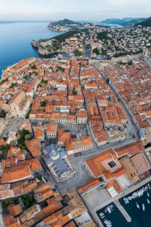 Téléchargez les photos : Vue panoramique aérienne de la pittoresque ville de Dubrovnik avec la vieille ville, rues étroites en pierre et bâtiments avec des toits rouges, marina avec des bateaux sur la côte Adriatique, Croatie. - en image libre de droit