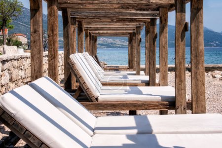 Téléchargez les photos : Chaises longues en bois à Orebic plage vide, péninsule de Peljesac, Croatie - en image libre de droit