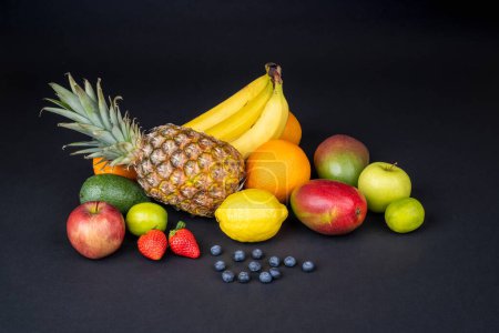 Still life with variety of fresh and ripe fruits arranged on a dark background. Fitness concept, diet, healthy lifestyle. Concept for elegant presentation of healthy food.	