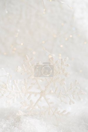 Foto de Copo de nieve blanco navideño sobre una nieve blanca. Fondo borroso con hermoso bokeh. Profundidad de campo superficial. Copiar espacio. Atmósfera aérea. Enfoque suave. - Imagen libre de derechos