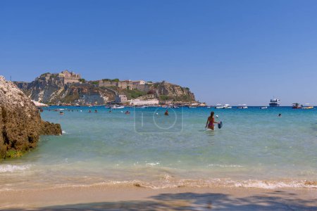 Photo for Tremiti Islands, Italy - 11 jul 2022: beach with bathers in front of the panorama of San Nicola in the Tremiti islands. High quality photo - Royalty Free Image