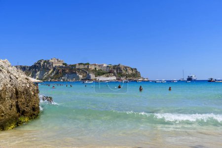Photo for Tremiti Islands, Italy - 11 jul 2022: beach with bathers in front of the panorama of San Nicola in the Tremiti islands. High quality photo - Royalty Free Image