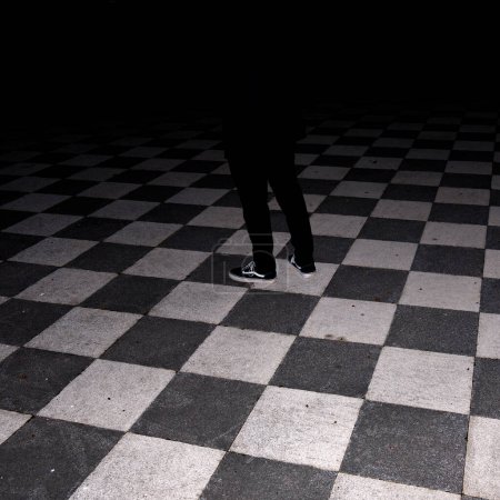 Téléchargez les photos : Mystérieux sol à carreaux avec une ombre au milieu de l'obscurité. Photo du QG - en image libre de droit
