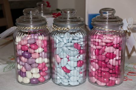 tres jarrones de vidrio que contienen confeti para los favores del bautismo. Foto de alta calidad