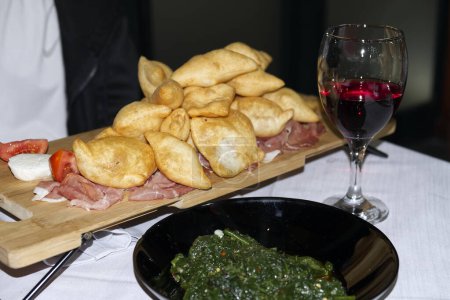 Italian appetizer. Fried bread crescentine or gnocco fritto with jambon and red wine. High quality photo