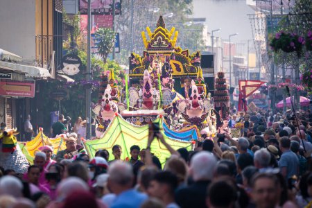 Foto de Chiang Mai, Thailand - February 4, 2023: Beautiful colorful Chiang Mai Flower Festival 2023 Parade on the old town street with fresh flowers decorated cars and people in traditional costumes. - Imagen libre de derechos
