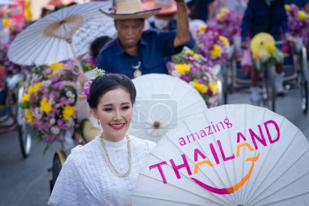 Téléchargez les photos : Chiang Mai, Thailand - February 4, 2023: Beautiful colorful Chiang Mai Flower Festival 2023 Parade on the old town street with fresh flowers decorated cars and people in traditional costumes. - en image libre de droit