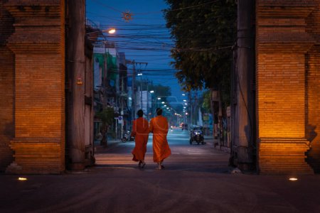 Téléchargez les photos : Chiang Mai, Thaïlande - Février 4, 2023 : Les moines marchent à travers la porte Tha Phae pour l'aumône le matin est ancienne porte de la ville sont célèbres lieu et destination le matin selon les croyances du bouddhisme en Thaïlande. - en image libre de droit