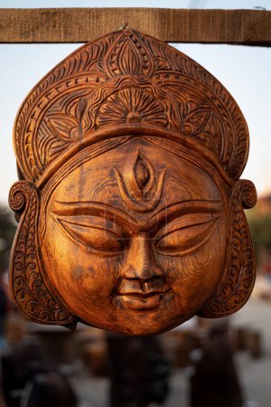 Téléchargez les photos : Belle sculpture en bois faite à la main de la déesse devi Durga est exposée dans une boutique à vendre en arrière-plan flou. Art et artisanat indiens. - en image libre de droit