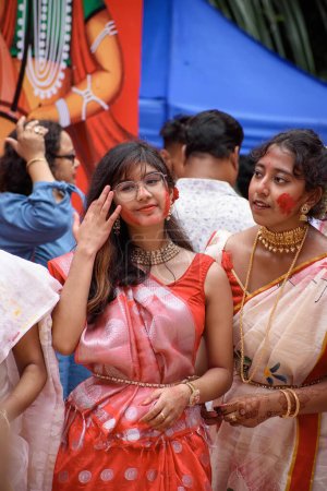 Téléchargez les photos : Portrait d'une belle jeune femme attirante portant une tenue traditionnelle bengali et participant à Sindur Khela lors d'un puja pandal le dernier jour de Durga puja. Kolkata, Inde le 05 octobre 2022 - en image libre de droit