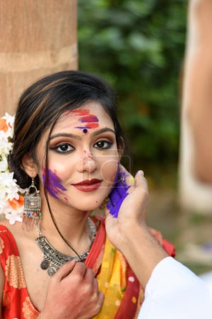 Junges Paar spielt mit Farben beim Fest der Farben namens Holi, einem beliebten hinduistischen Fest, das in ganz Indien gefeiert wird.