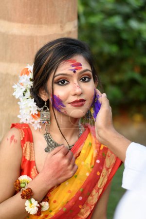 Junges Paar spielt mit Farben beim Fest der Farben namens Holi, einem beliebten hinduistischen Fest, das in ganz Indien gefeiert wird.