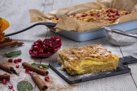 Photo for Kurdish pastry with cheese. A special and traditional pastry, sprinkled with powdered sugar and garnished with pomegranate and cinnamon. - Royalty Free Image