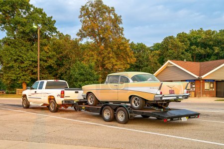 Photo for Carleton MI - September 17, 2022: Yellow 57 Chevy on a trailer being hauled by pickup truck. High quality photo - Royalty Free Image