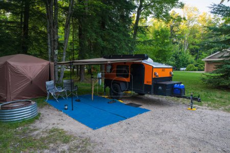 Photo for Paradise, MI - August 9, 2023: An orange and black Hiker teardrop camper parked in at a State Park. High quality photo - Royalty Free Image