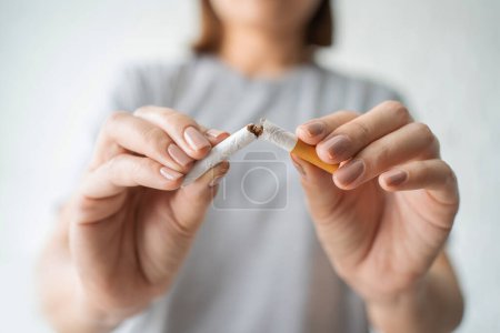 Foto de Mujer bella feliz de romper un cigarrillo. Día Internacional del tabaco Wold y dejar de fumar concepto de cigarrillos. - Imagen libre de derechos