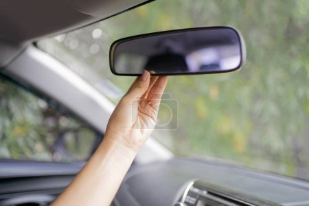 Foto de Las mujeres asiáticas están ajustando el espejo retrovisor del coche - Imagen libre de derechos