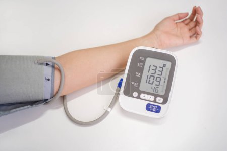 Frau misst Blutdruck mit elektronischem digitalen Tonometer, weibliche Hand in Großaufnahme. Arterielle Hypotonie und kardiologisches Konzept