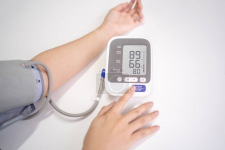 Mujer mide su presión arterial
.