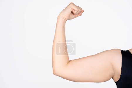 Photo of young woman with excess fat on upper arms isolated on white background. Overweight. Beauty concept.
