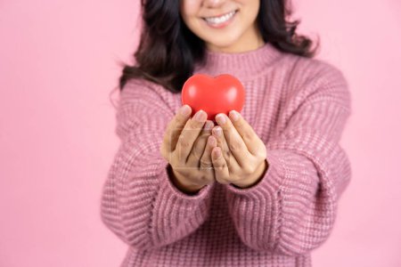 Téléchargez les photos : Woman hands holds red heart on pink pastel  background with copy space. - en image libre de droit