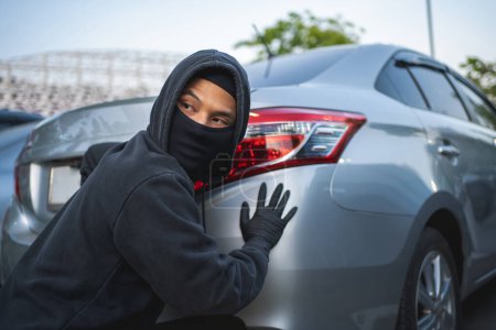 Photo for Masked thief in action before burglary. Car thief criminal concept. - Royalty Free Image