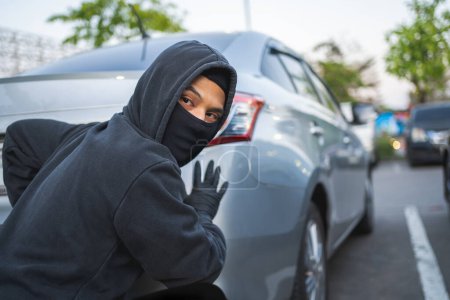 Foto de Un ladrón con una máscara de robo tratando de robar un autobmobile - Imagen libre de derechos