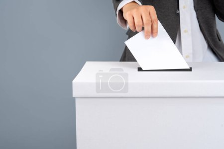 A voter holds vote ballot paper in the ballot box. Election concept.