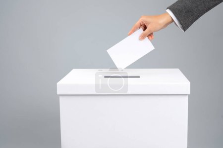 Photo for Man putting his vote into ballot box, closeup. The concept of free democratic vote elections. - Royalty Free Image