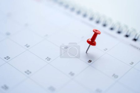 Kalender mit roten Anstecknadeln am 9., Datum der Veranstaltung mit Anstecknadeln markieren.