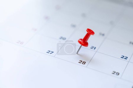 Selective focus. Photo picture of a calendar with a red pin on the 28th.
