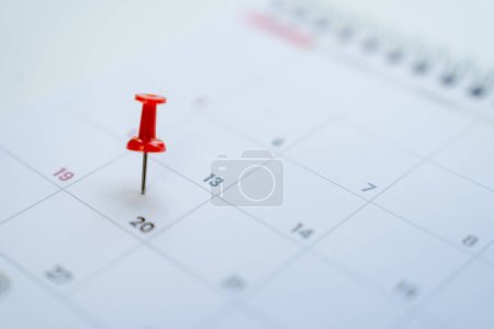 Close-up view of red pins with calendar for event planner event