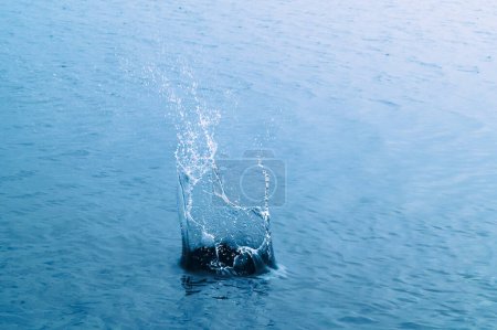 Téléchargez les photos : Impact splash on water surface after stone throwing. - en image libre de droit