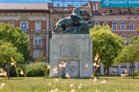 Foto de Budapest, Hungary - July 04, 2022: Przemysl Memorial is in Buda, at the west end of Margaret Bridge. The monument depicts a roaring lion as it surmounts a flag draped over a cannon - Imagen libre de derechos