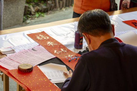Téléchargez les photos : Le calligraphe chinois du Festival de Printemps écrit à la main couplet du Festival de Printemps (texte : Ruyi de bon augure, auspicieux, bénédiction, printemps) - en image libre de droit