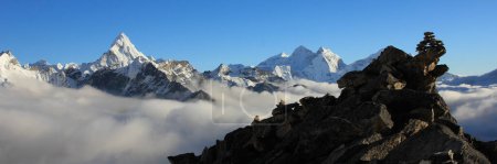 Photo for Cairns on Kala Patthar, sea of fog and peak of Mount Ama Dablam. - Royalty Free Image