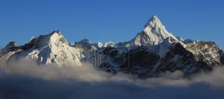 Le mont Ama Dablam et d'autres montagnes enneigées s'étendant d'une mer de brouillard, au Népal.