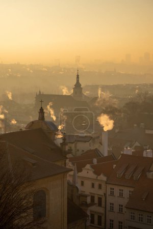 Téléchargez les photos : Plan du matin des toits de la vieille ville éveillée avec de la fumée provenant des cheminées, Prague la capitale de la République tchèque - en image libre de droit
