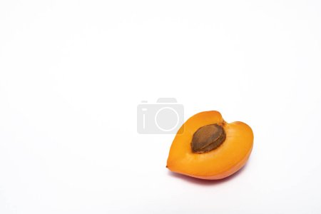 Téléchargez les photos : Photo studio d'un abricot fendu avec un noyau sur fond blanc - en image libre de droit
