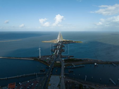 Photo for The Afsluitdijk flood defense system in the Netherlands between North Holland and Friesland closing the IJsselmeer off from the Wadden Sea. Dam and road infrastructure aerial drone view. - Royalty Free Image