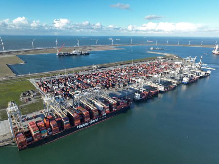 Foto de Rotterdam, 19th of January 2023, The Netherlands. Container ship Hapag-Lloyd unloading at the Port of Rotterdam involves removing cargo containers from the vessel using cranes or other equipment - Imagen libre de derechos