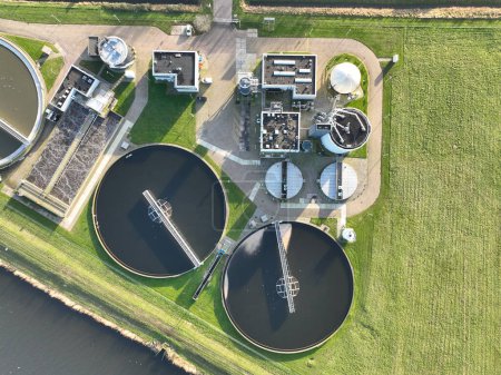 Téléchargez les photos : D'en haut, le réseau complexe de tuyaux, de réservoirs et de systèmes de filtration dans une usine de traitement des eaux usées est exposé en détail. - en image libre de droit