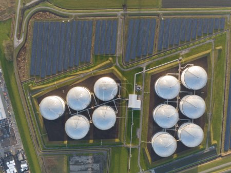 Photo for Witness the contrast between the old and new ways of energy production through a birds eye view of oil storage tanks and solar panels coexisting in a single location. - Royalty Free Image