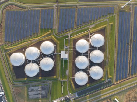 Photo for Experience the scale and complexity of energy infrastructure with a mesmerizing top-down drone footage of an industrial facility featuring oil storage and solar panels. - Royalty Free Image