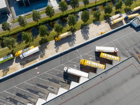 Téléchargez les photos : Woerden, 14 juin 2023, Pays-Bas. Vue du haut vers le bas sur le parking de camions à plusieurs niveaux au centre de distribution Jumbo. Vue aérienne du drone. - en image libre de droit