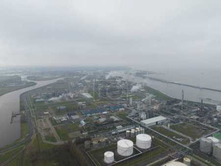 Téléchargez les photos : Delfzijl, Groningue, Pays-Bas 3 décembre 2023 : Usine chimique dans le port de Delfzijl. Grands conteneurs de silos et usine. Oiseaux oeil vue aérienne de drone. - en image libre de droit