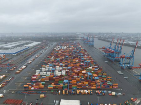Photo for Hamburg, Germany, December 30th, 2023: Altenwerder container terminal, loading and unloading of containers on transportation ships. Birds eye aerial drone view. - Royalty Free Image