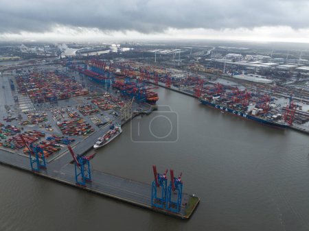 Foto de Hamburgo, Alemania, 30 de diciembre de 2023: Terminal de contenedores de Hamburgo. Puerto marítimo en el río Elba en Hamburgo, Alemania, a 110 kilómetros de su desembocadura en el Mar del Norte. Vista aérea del dron. - Imagen libre de derechos