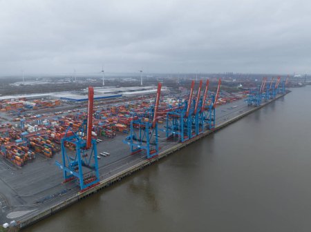 Photo for Hamburg, Germany, December 30th, 2023: Altenwerder container terminal, loading and unloading of containers on transportation ships. Birds eye aerial drone view. - Royalty Free Image